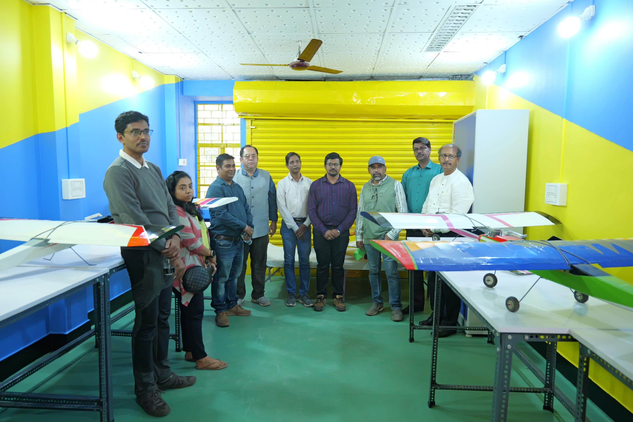 Weevils Drones team on the STEP workshop floor at IIT Kharagpur on inauguration day, multiple fixed-wing airframes on workbenches