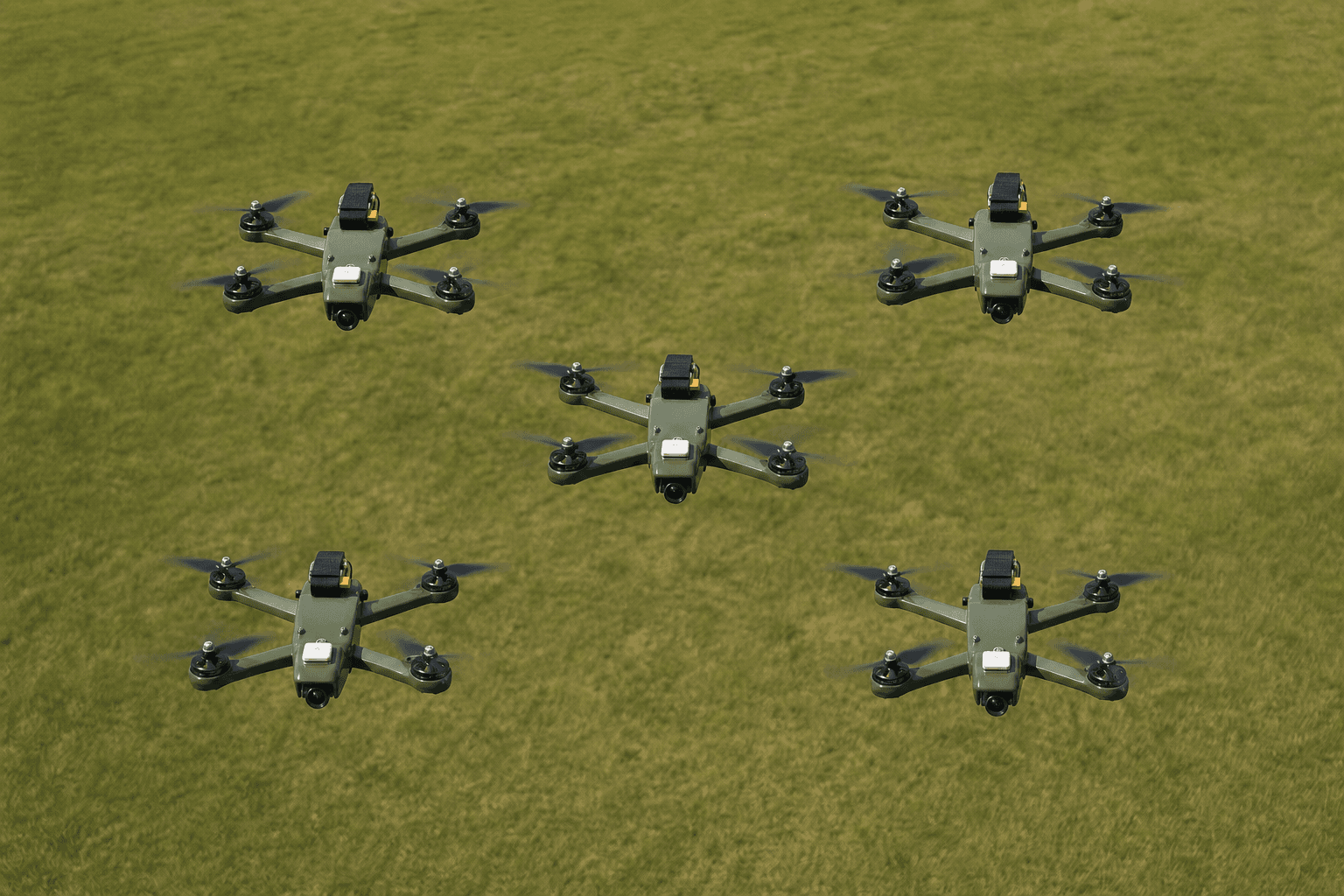 Zeus 5-inch quadcopters in a master–slave swarm formation on a grass field