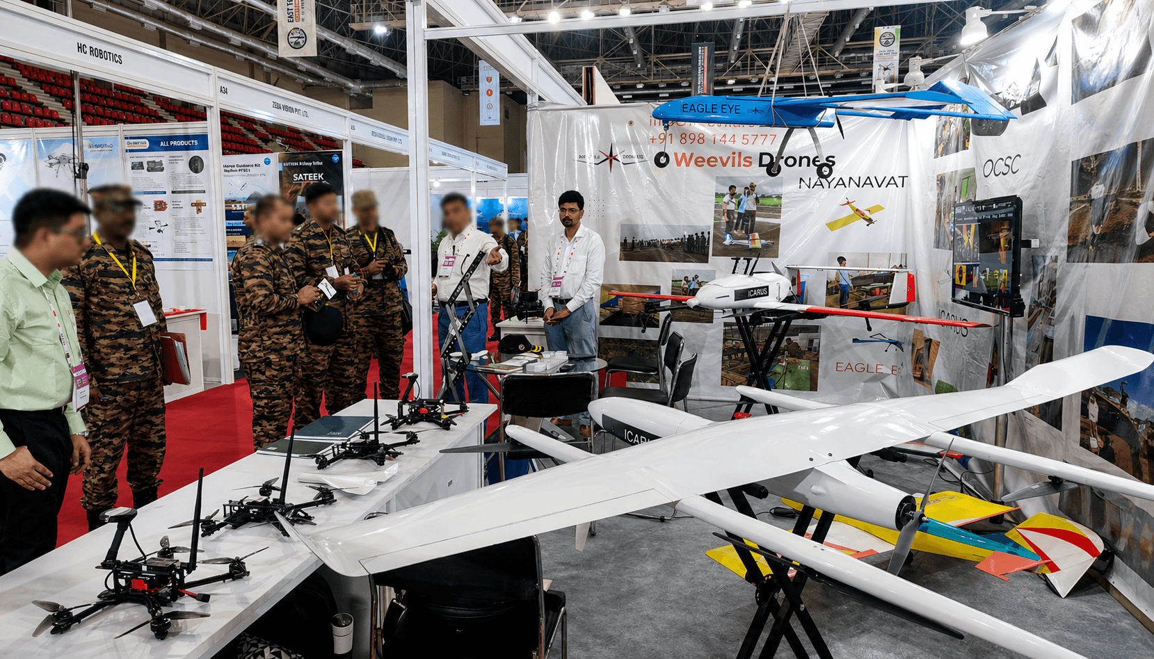 Weevils Drones exhibition booth at East Tech 2025 with the Nayanavat banner and the full platform lineup on display